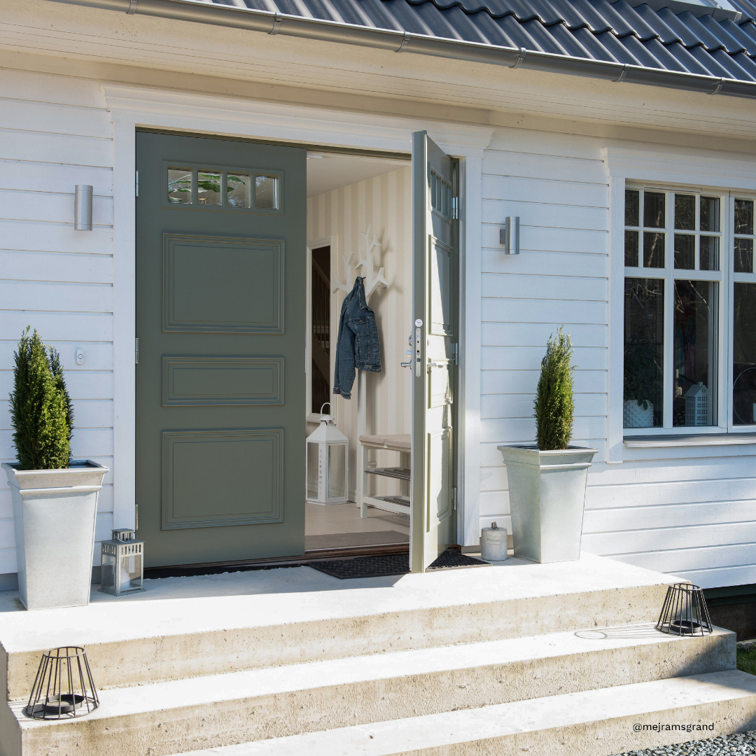 Pardörren i färgen NCS S 5010-G70Y pryder ett fint hus i Åhus.
